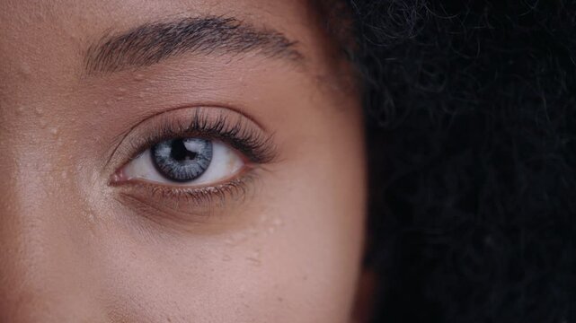 Close-up of beautiful african young woman face with cool digital eye with micro chips inside. Macro view.