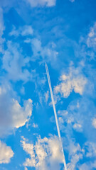 Jet Airplane Leaving Contrails in a Vibrant Blue Sky with Clouds
