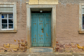 Old wooden door framed by textured walls in a charming historic village at golden hour