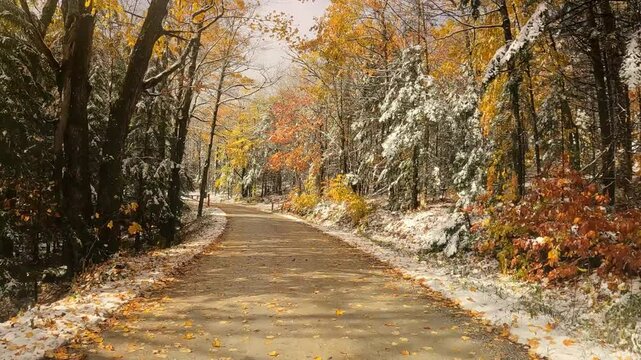 USA, New England, Vermont, 4x4 driving along old CCC (Civilian Conservation Corps) dirt road, running between North Shrewsbury and Route 100. Trees in late fall colors line the snowy road.
