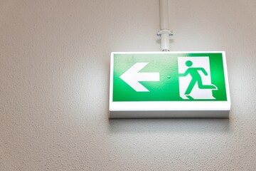 Fire Emergency exit sign on the wall background inside building. Safety concept