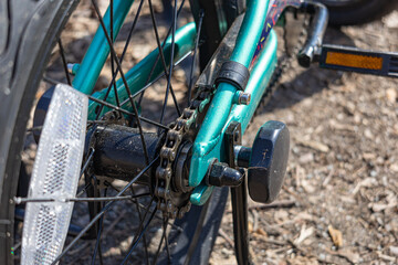 Detailed image of a bicycle's rear wheel showing the chain, gears, and reflector