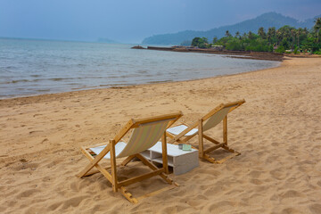 sun beach chairs on shore near sea.