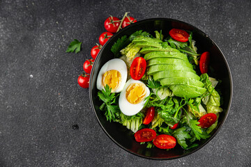 Avocado salad, boiled egg, tomato, green leaf lettuce, vegetable dish fresh delicious gourmet food background on the table rustic food top view copy space keto and paleo diet vegetarian food