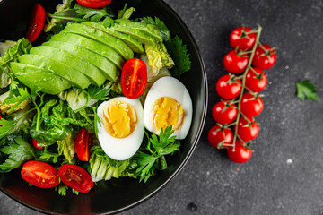 Avocado salad, boiled egg, tomato, green leaf lettuce, vegetable dish fresh delicious gourmet food background on the table rustic food top view copy space keto and paleo diet vegetarian food