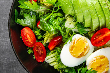 Avocado salad, boiled egg, tomato, green leaf lettuce, vegetable dish fresh delicious gourmet food background on the table rustic food top view copy space keto and paleo diet vegetarian food