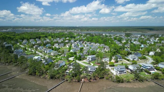 Aerial shot of wealthy subdivision during a bright sunny day with clouds.
