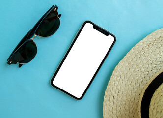 Mockup, smartphone, sunglasses and a hat on a blue background. Summer vacation.