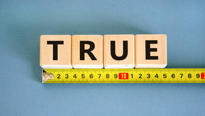 True symbol. Concept word True on beautiful wooden blocks. Beautiful yellow ruler. Beautiful blue...