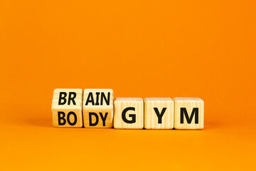 Body vs brain gym symbol. Turned wooden cubes and changed words Body gym to Brain gym. Beautiful orange table orange background, copy space. Business and body vs brain gym concept.