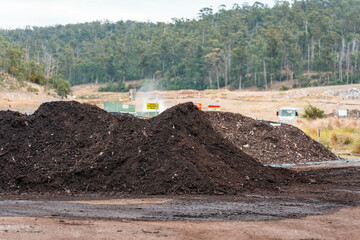 turning a compost windrow pile in a community garden. compost full of microorganisms. sustainable...