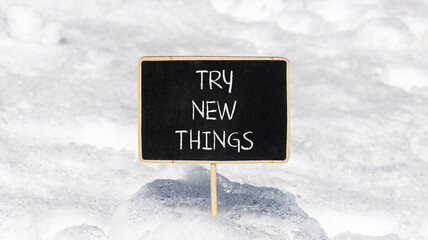 Try new things symbol. Concept words Try new things on beautiful blackboard. Beautiful white snow background. Business motivational lifestyle try new things concept. Copy space.