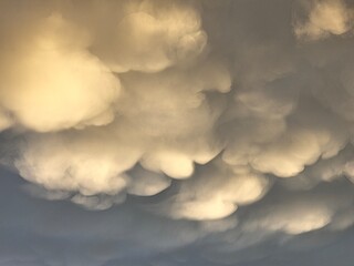 Storm clouds on sunset. Light in the dark and dramatic storm clouds. Background of storm clouds before a thunderstorm. Mammatus clouds