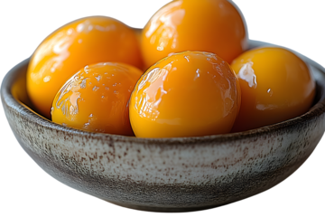 Closeup of shiny yellow egg yolks in a rustic bowl