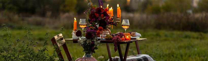 Banner. Beautiful elegant autumn table setting for thanksgiving family dinner or wedding. Pumpkin with flowers as centrepiece. Cozy fall home atmosphere. Wineglass, romantic marriage proposal, sunset