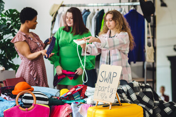 Students, young attractive people at home swap party, trying vintage clothes, bargain hunting. Sustainable lifestyle of generation z, eco friendly fashion, conscious consumerism, consignment stores