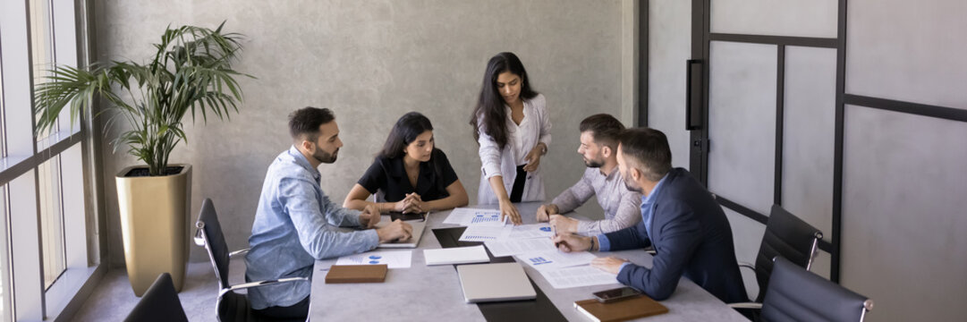 Group of businesspeople gathered in boardroom for project or business strategy planning, reviewing financial data, preparing for presentation, wide view. Teamwork, collaboration, team contributions - Powered by Adobe