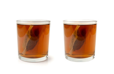 Herbal tea sachet in glass, hot water with chamomile and Hypericum or St. John's wort teabag