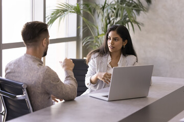Two diverse businesspeople engaged in focused professional collaborative conversation, productive...