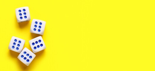 Dices on yellow background with space for text, top view