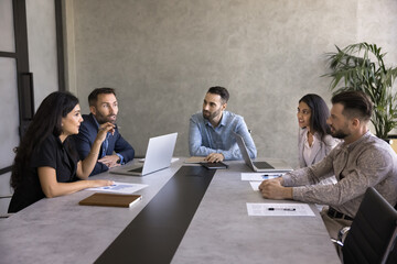 Group of business professionals take part briefing in boardroom, listen team member express opinion...