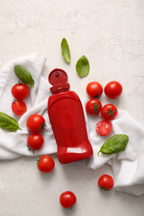 Bottle of ketchup and tomatoes on white background