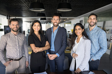 Group of multinational successful teammates standing in row, exuding professionalism, leadership, unity. Five businesspeople, staff members, representing company posing for camera in corporate office