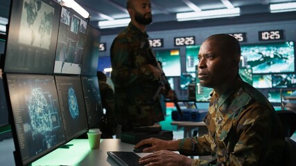 Army software developer employing AI tech in military planning and decision making. African american IT specialist uses artificial intelligence to enhance combat operational capabilities, camera B