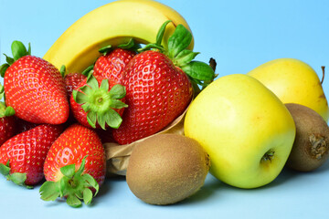 Assorted fruit on a light blue background, healthy food.