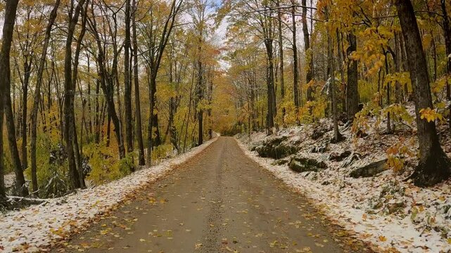 USA, New England, Vermont, 4x4 driving along old CCC (Civilian Conservation Corps) dirt road, running between North Shrewsbury and Route 100. Trees in late fall colors line the snowy road.