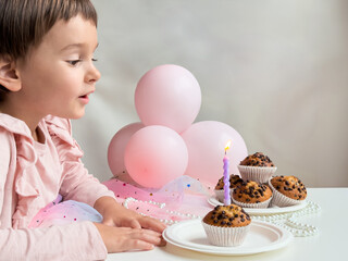 Caucasian child celebrating birthday with cupcakes and candle. Birthday concept.