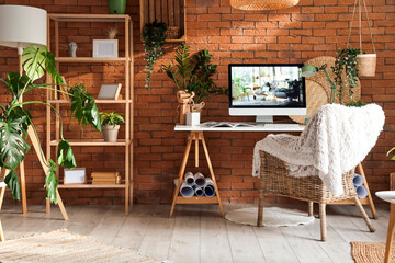 Interior of office with workplace, green plants and shelf unit