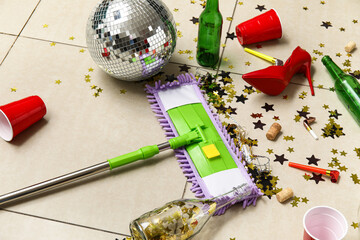 Mop with mess on tile floor after party, closeup