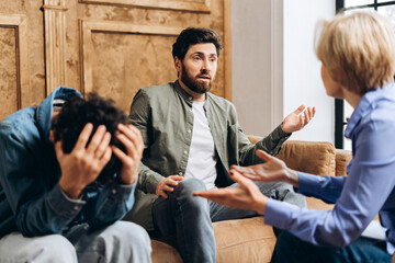 Father and teenage boy visiting psychologist to discuss problems