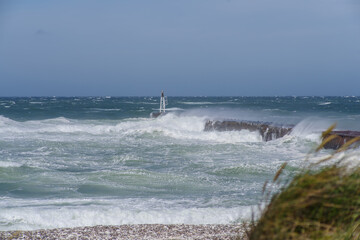 Stormy Sea with Waves Crashing Against Pier and Marker