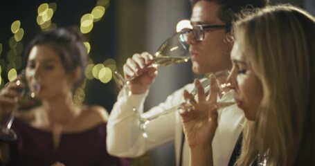 Close-knit friends raise their glasses in a toast, clinking champagne flutes at a glamorous celebration. The room is filled with laughter and joy as they enjoy an elegant evening of festivities