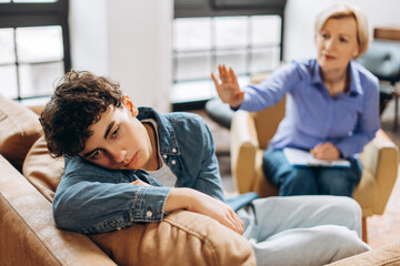 Female psychologist talking to teenage boy during a therapy session