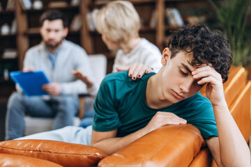 Tired teenage boy after long consultation with a psychologist with his mother