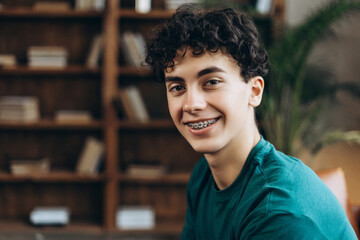 Happy teenage boy with braces looking at camera, fashion model posing