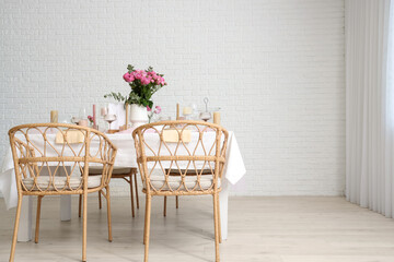 Beautiful table setting with pink roses and candles for wedding celebration in room