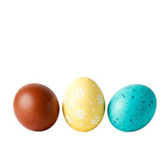 Obraz premium Three uniquely decorated Easter eggs—a rich brown, a sunny yellow with delicate white flowers, and a speckled teal—resting against a pristine white background.
