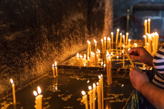 Western Asia, Eurasia, South Caucasus, Republic of Armenia. Sevan. August 15, 2018. Worshippers with candles inside of the church of Surp Arakelots at the Sevanavank Monastery complex on Lake Sevan.