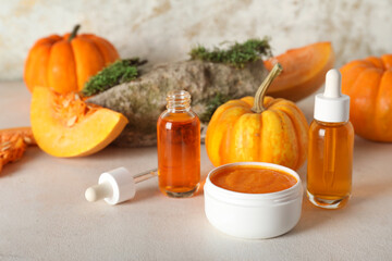 Bottles of cosmetic pumpkin oil and jar of mask on white background