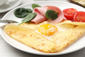 Delicious crepe with egg, ham and parmesan cheese on table, closeup