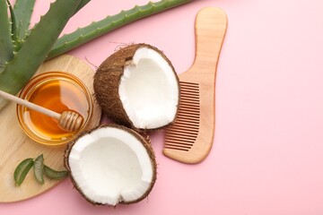 Hair treatment. Fresh coconut, honey, comb and aloe leaves on pink background, flat lay. Space for text