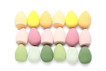 Colorful makeup sponges on white background