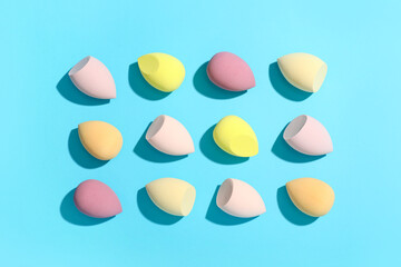 Colorful makeup sponges on blue background