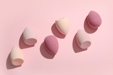 Many makeup sponges on pink background