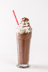 A tall glass of chocolate milk with a red straw in it. The straw is sticking out of the top of the glass