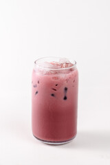 A glass of pink drink is sitting on a white background. The drink is cold and has a pinkish color
